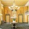 a room with a chandelier and a table with flowers on it