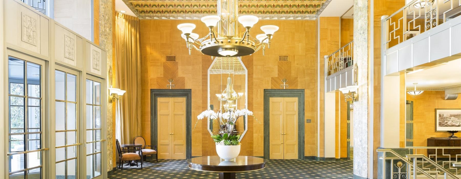 a room with a chandelier and a table with flowers on it